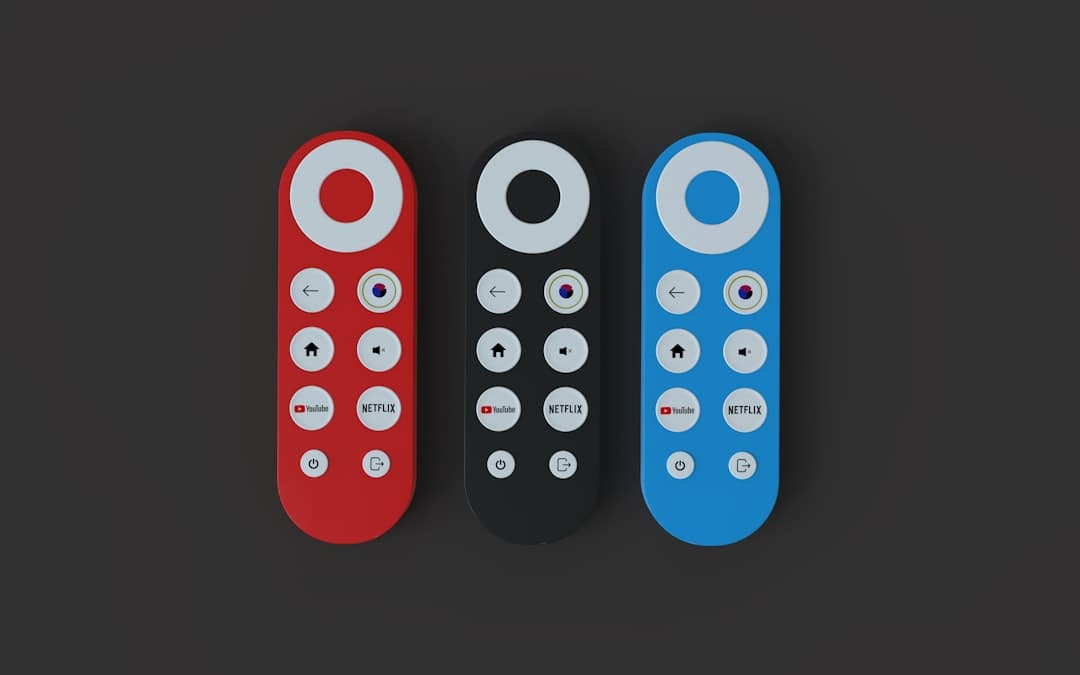 Petit boîtier Android TV posé près d'un téléviseur avec sa télécommande