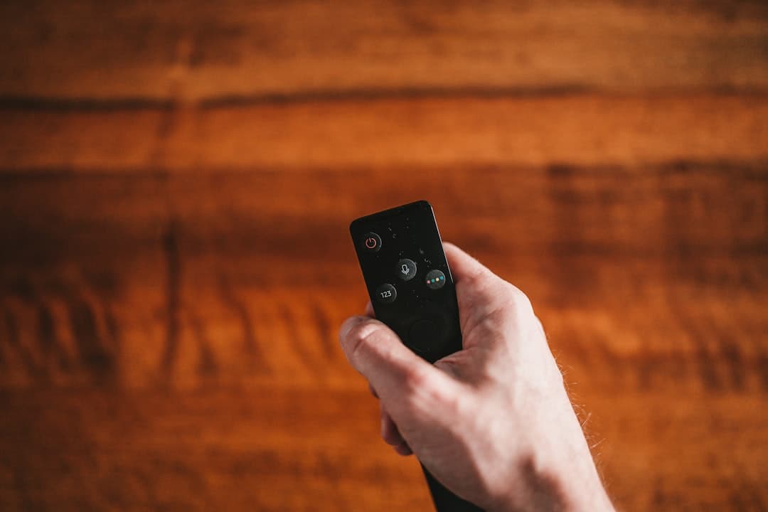 Personne tenant une télécommande devant un téléviseur affichant une erreur